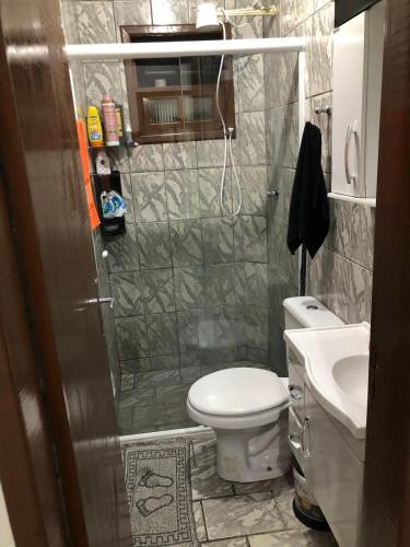 a small bathroom with a toilet and a sink at Sobrado na Praia de Matinhos in Matinhos