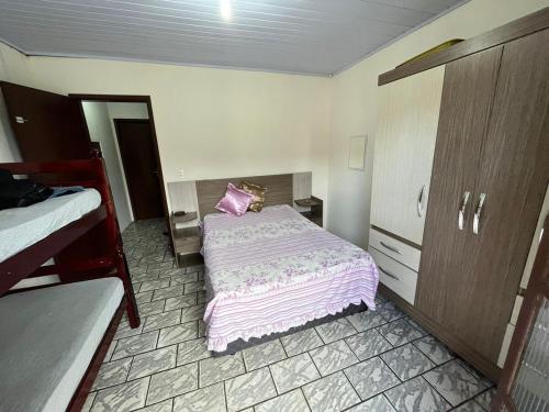 a bedroom with a bed with a pillow on it at Sobrado na Praia de Matinhos in Matinhos