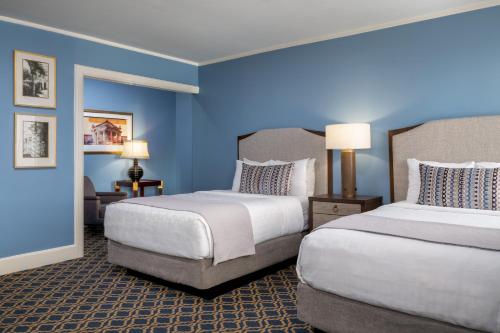 two beds in a room with blue walls at Francis Marion Hotel in Charleston