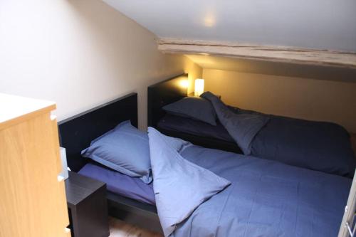 une chambre avec un lit avec des draps et des oreillers bleus dans l'établissement Moulines 10 bis, à Lansargues
