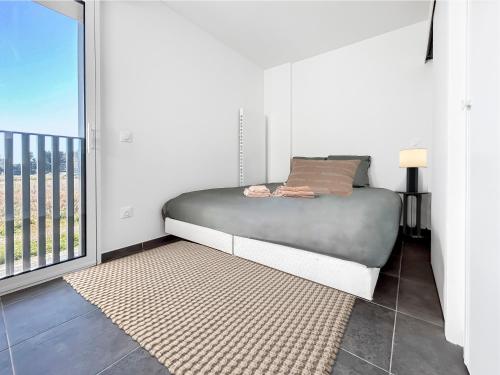 une chambre avec un lit et un balcon dans l'établissement Studio SO WOOD lumineux avec vue dégagée, à Montpellier