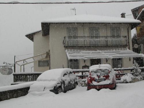 a snow covered car parked in front of a house at Locanda del Pittore in Arcumeggia