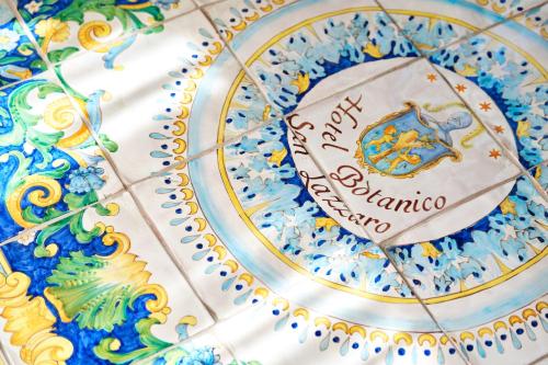 a blue and white cake with a sign on it at Hotel Botanico San Lazzaro in Maiori