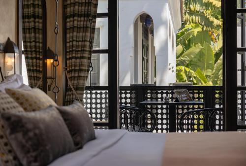 a bedroom with a bed and a balcony with a window at Villa Maroc Resort in Pran Buri