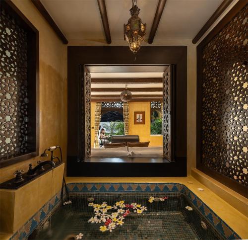 a bathroom with a tub and a sink and a mirror at Villa Maroc Resort in Pran Buri