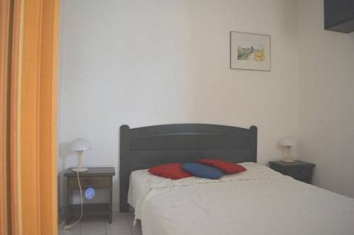 - une chambre avec un lit et 2 oreillers rouges et bleus dans l'établissement Appartement 2 pièces cabine 6 couchages ARGELES SUR MER AR260-309, à Argelès-sur-Mer