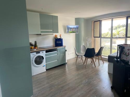a kitchen with a washing machine and a table and chairs at Center Marina view Green Studio in Funchal