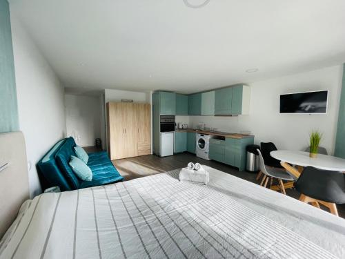 a bedroom with a bed and a kitchen and a table at Center Marina view Green Studio in Funchal