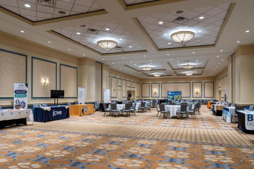 a conference room with tables and chairs and a screen at Francis Marion Hotel in Charleston