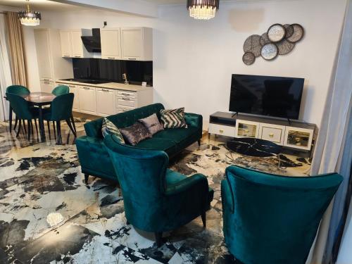 a living room with a couch and chairs and a television at Luminia Gold Bradet in Zalău
