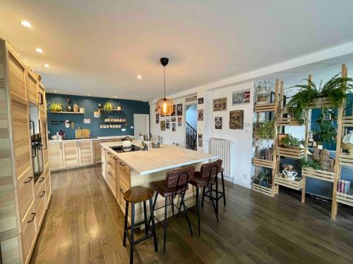 a kitchen with a large island with stools in it at Grande maison à 200m de la plage in Plouguerneau