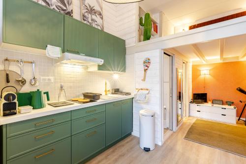 une cuisine avec des placards verts et un comptoir dans l'établissement Surfing-House Biarritz, à Biarritz