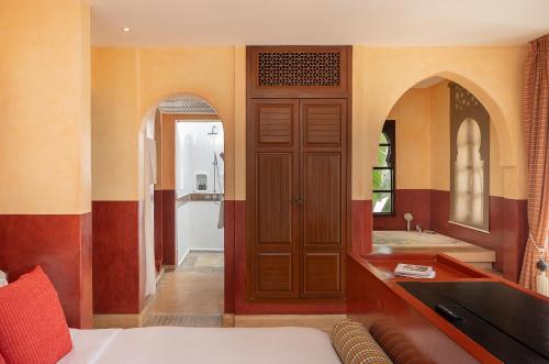 a bedroom with a bed and a bathroom with a tub at Villa Maroc Resort in Pran Buri