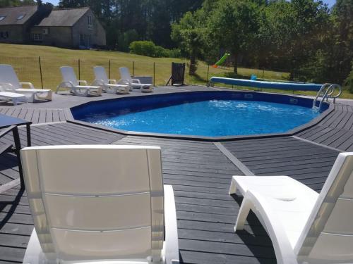 - une piscine sur une terrasse entourée de chaises dans l'établissement Bonne Chere, Family Friendly Cottage with Pool LPS, à Malguénac