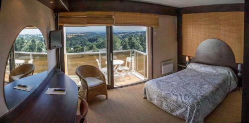 Schlafzimmer mit einem Bett und Blick auf einen Balkon in der Unterkunft authentic by balladins – Rodez / Le Ségala in Baraqueville