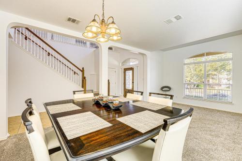 a dining room with a wooden table and white chairs at 5 Mi to Randolph AFB Spacious Cibolo Haven! in Cibolo
