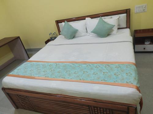 a bedroom with a large bed with green pillows at Hotel Golden Buddha Inn Bodhgaya in Bodh Gaya