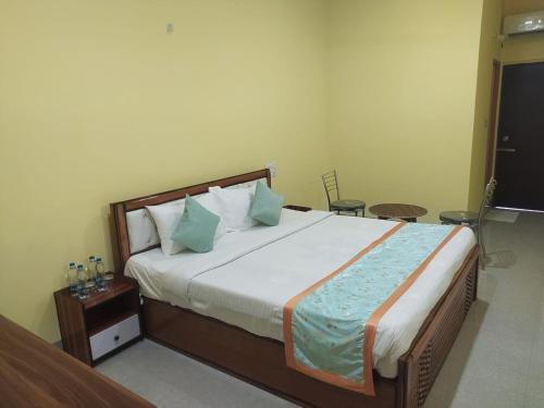 a bedroom with a large bed with blue pillows at Hotel Golden Buddha Inn Bodhgaya in Bodh Gaya
