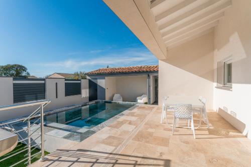 une terrasse avec une piscine, une table et des chaises dans l'établissement Villa avec piscine extérieur, à Saint-Géniès-de-Malgoirès