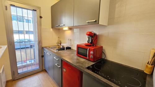 une cuisine avec un appareil rouge sur un comptoir dans l'établissement Nice studio center of Montpellier, à Montpellier