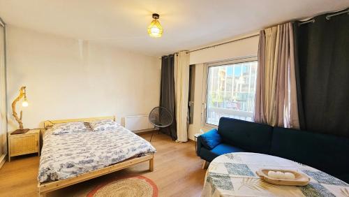 une chambre avec un lit, un canapé et une fenêtre dans l'établissement Nice studio center of Montpellier, à Montpellier