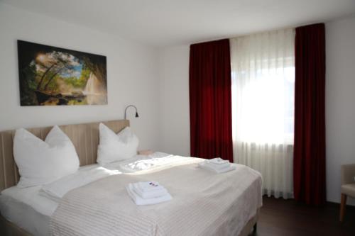 a hotel room with a bed with towels on it at Hotel Garni Alte Post in Schallbach
