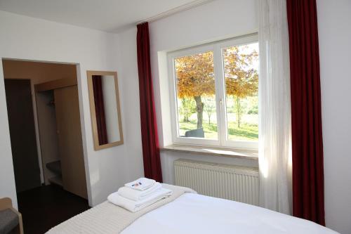 a bedroom with a white bed and a window at Hotel Garni Alte Post in Schallbach