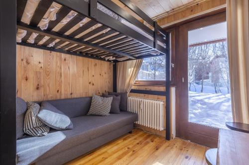 Un sofá sentado en una habitación con ventana. en Résidence Les Crêts 1 - Val-d'Isère, en Val dʼIsère
