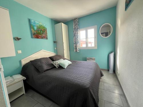 une chambre avec un lit aux murs bleus dans l'établissement Superbe T2 face mer piscine, à Six-Fours-les-Plages
