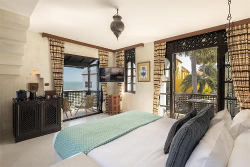a bedroom with a bed and a balcony at Villa Maroc Resort in Pran Buri