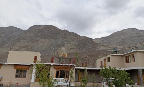 a house with mountains in the background at Tsogstot residency in Deskit