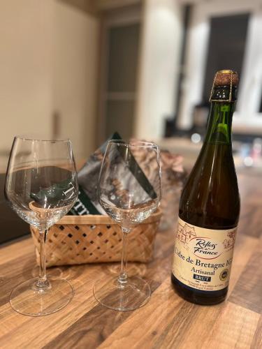 une bouteille de vin et deux verres sur une table dans l'établissement Bel appartement centre-ville, à Lorient
