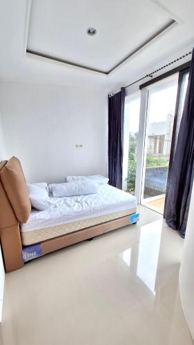 Una cama sentada en una habitación con ventana. en SERENA Villa, en Batu