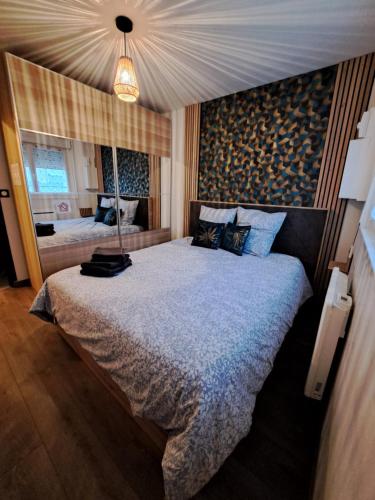 une chambre avec un grand lit et une fenêtre dans l'établissement Eco-Logis le 50, maison avec jardins et terrasse privatifs, à Mondeville