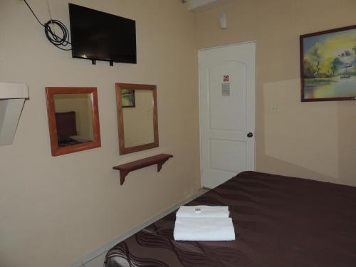 a bedroom with a bed and a television on the wall at Hacienda Cañada Rica 2 in Ciudad Madero