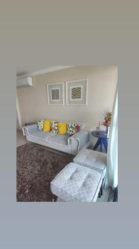 a living room with a couch and a table at Luxor Paulo Miranda Frente ao mar in João Pessoa