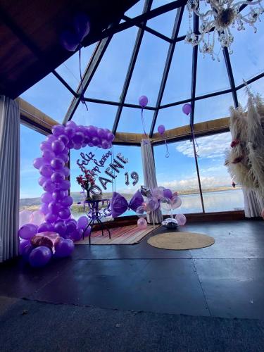 a room with purple balloons and a large window at Uros Titicaca Beluxia in Puno