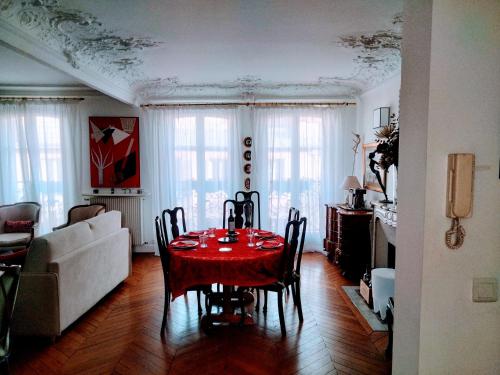 une salle à manger avec une table et des chaises rouges dans l'établissement Batignolles chic 75 m2, à Paris