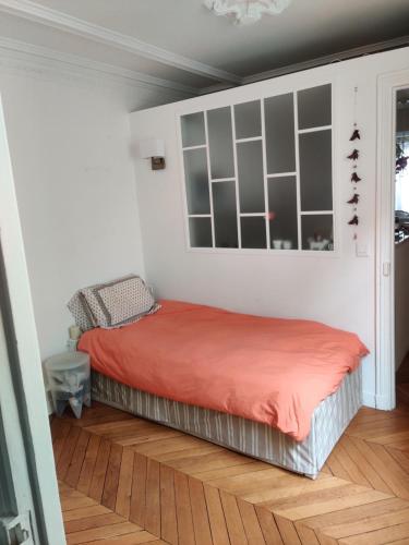 une chambre avec un lit avec une couverture rouge dans l'établissement Batignolles chic 75 m2, à Paris