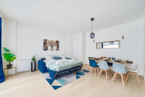 une chambre avec un lit, une table et des chaises dans l'établissement Stylish 3 bdr & Garden Oasis on the Edge of Paris, à Saint-Mandé