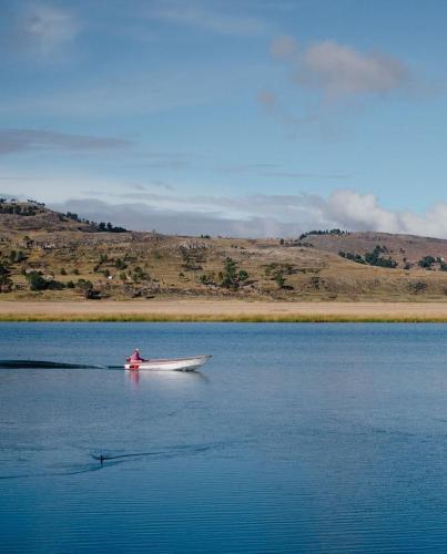 a boat in the middle of a body of water at Uros Titicaca Beluxia in Puno