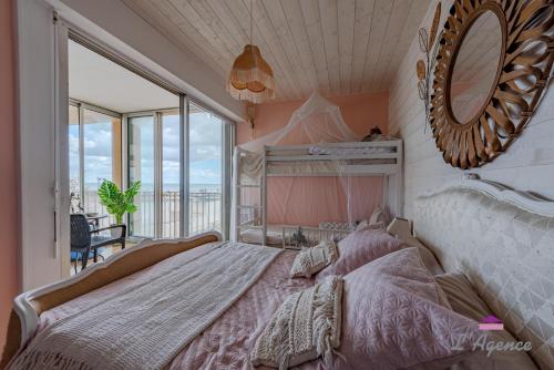 a bedroom with a large bed and a mirror at Le Nid Cosy accès direct sur la mer in Le Barcarès