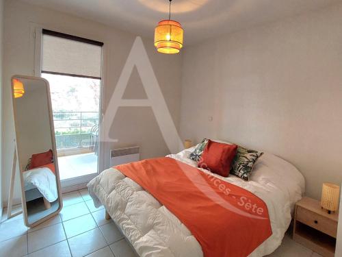 une chambre avec un lit et une grande fenêtre dans l'établissement T3 renove dans residence avec piscine et garage Capacite max 6 personnes, à Sète