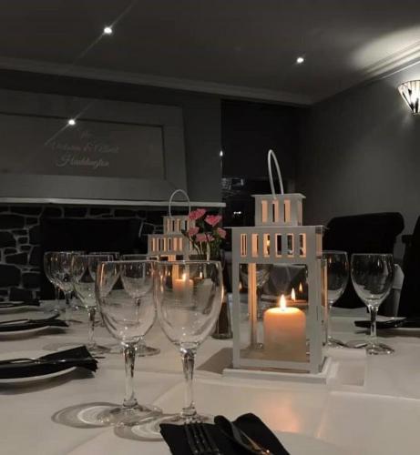 a table with wine glasses and a candle on it at The Victoria Inn in Haddington
