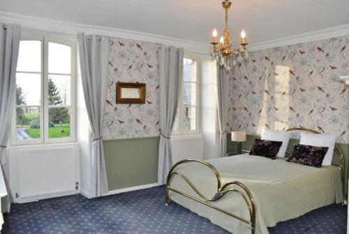 une chambre avec un lit et un lustre dans l'établissement Country House La Feronnière, à Le Mesnil-Amand