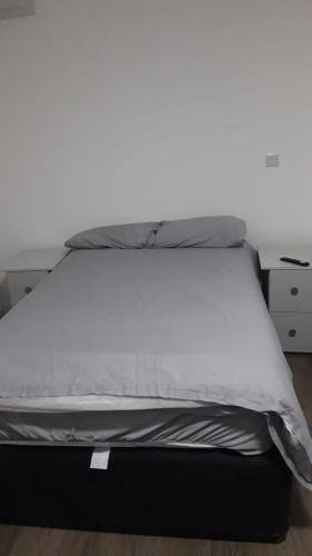 a bed with a white mattress and a desk at DON VALLEY ARENA APPARTMENTs in Attercliffe