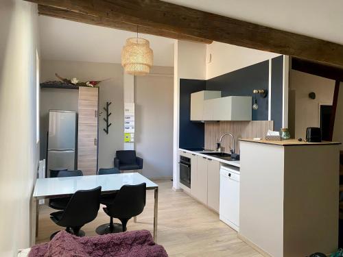 une cuisine avec une table et des chaises dans une pièce dans l'établissement Appartement atypique centre village, à Rillieux-la-Pape