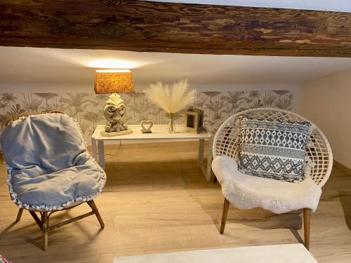 un salon avec deux chaises et une table dans l'établissement Appartement atypique centre village, à Rillieux-la-Pape