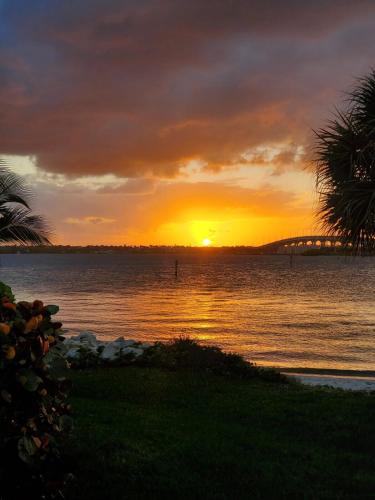 a sunset over a body of water with the sun setting at Margarita-Ville on the water! Stunning Sunsets!! in Jensen Beach