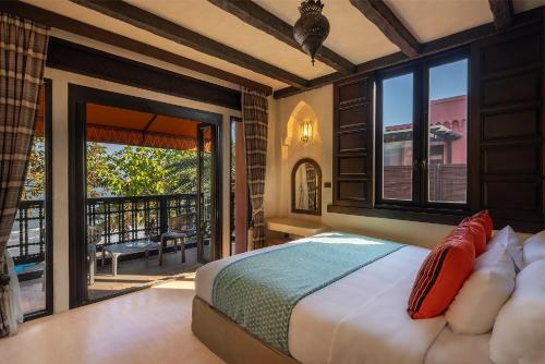 a bedroom with a bed and a balcony at Villa Maroc Resort in Pran Buri